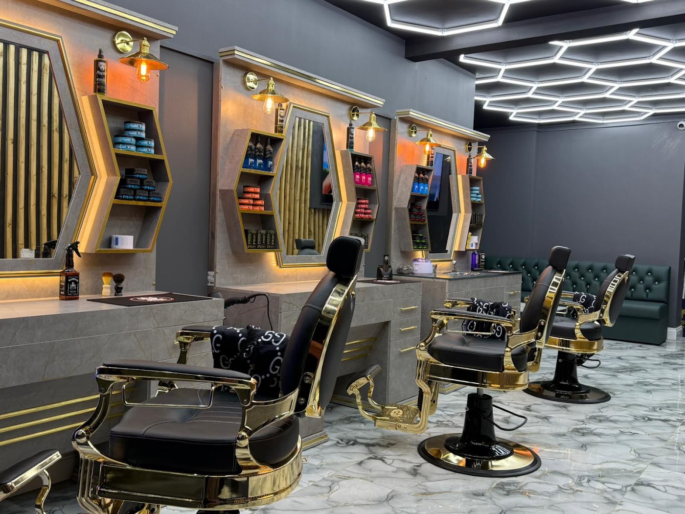 Inside ZK Barber's with gold chairs and hexagon lights